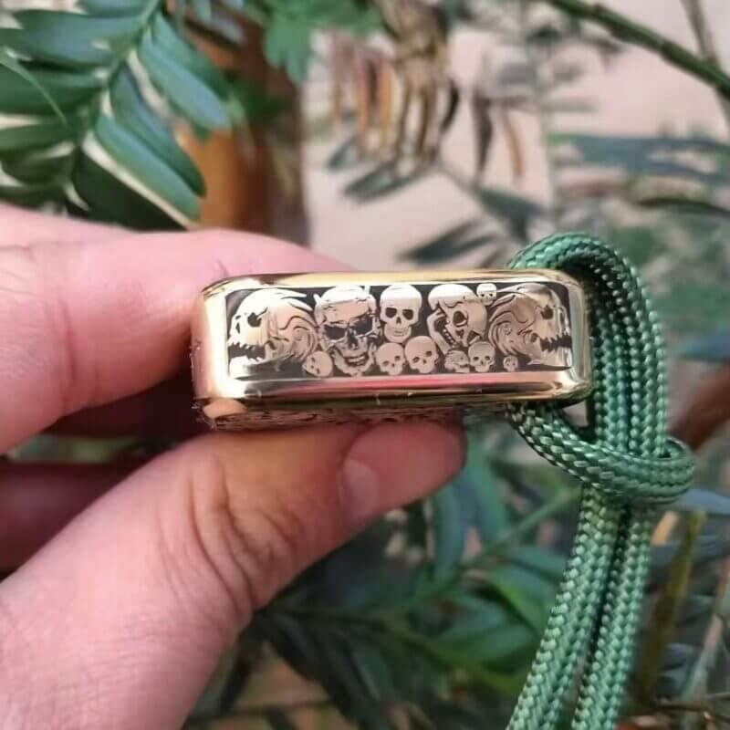 A side view of finely carved brass knuckles self defense featuring a skull motif, designed for self-defense