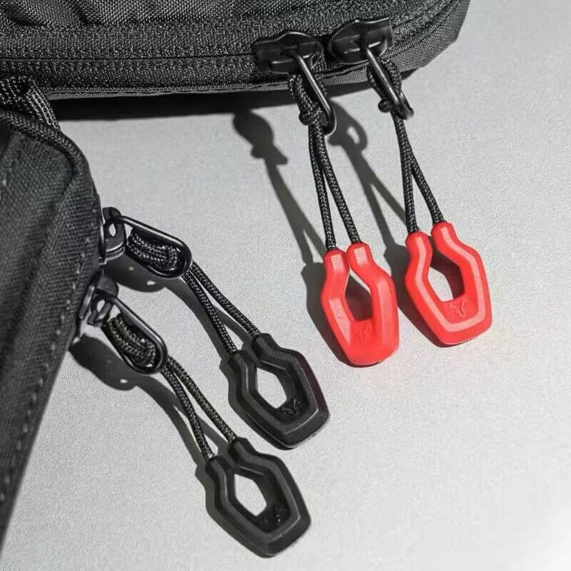 Orange and black zipper pull replacements attached to a backpack zipper